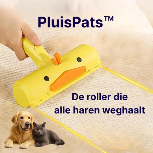 Herbruikbare PluisPats™ haarverwijderaar in eendvorm, in actie op een tapijt – verwijdert efficiënt huisdierharen zonder plakkerige rollers.